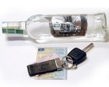Butelka po alkoholu a przy niej kluczyki do samochodu