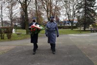 Komendant policji i komendant straży niosą kwiaty