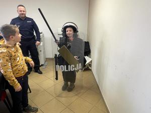 Na zdjęciu dzieci przymierzające sprzęt policyjny