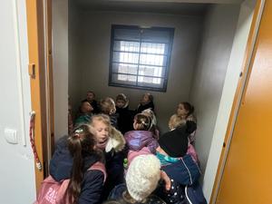 Na zdjęciu dzieci oglądający pomieszczenie dla osób zatrzymanych