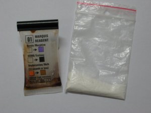 Na zdjęciu tester narkotykowy oraz woreczek foliowy z zawartością białego proszku